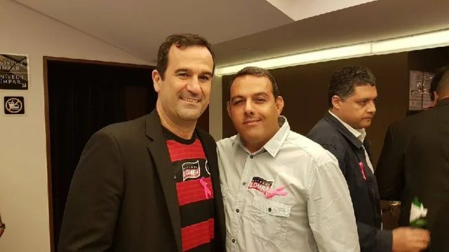 Ricardo Lomba (esquerda) e Cacau Cotta (direita) sorriem para foto durante candidatura da Chapa Rosa