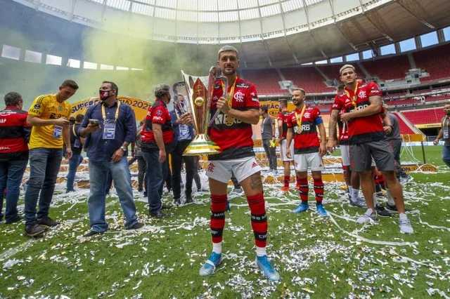 Arrascaeta posa para foto com a taça da Supercopa do Brasil de 2021