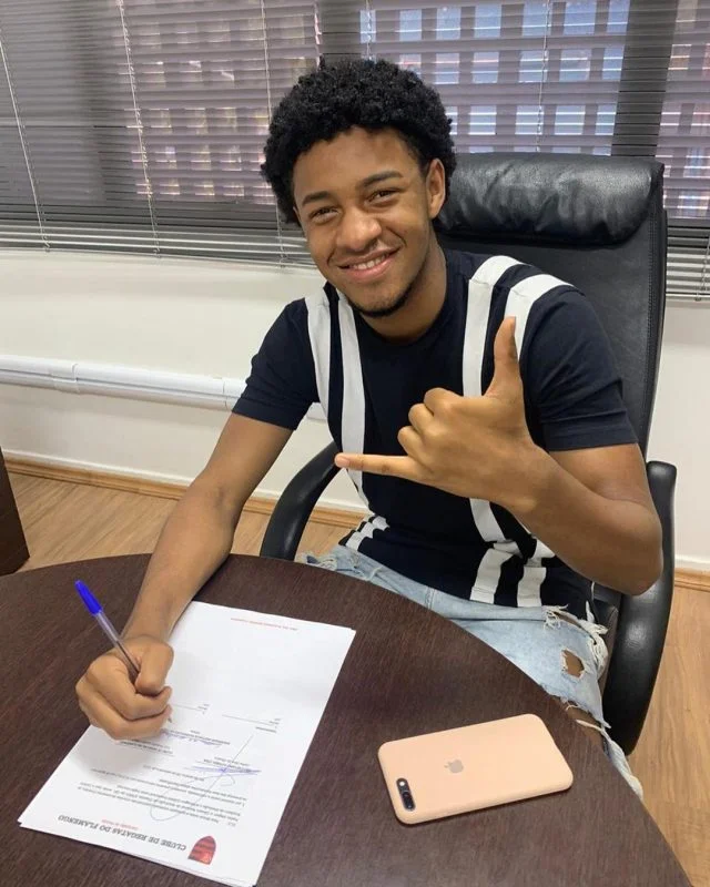 Cuadrado sorri para foto no momento em que assina o contrato com o Flamengo