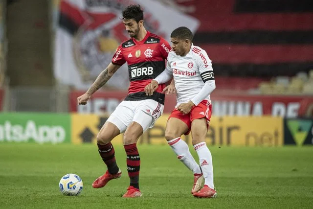Gustavo Henrique e Taison durante uma disputa de bola no decorrer do jogo entre Flamengo e Internacional pelo Campeonato Brasileiro de 2021