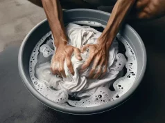 Homem lavando roupas brancas para tirar mofo