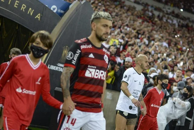 Jogadores de Flamengo e Corinthians entrando no gramado do Maracanã para jogo da Libertadores