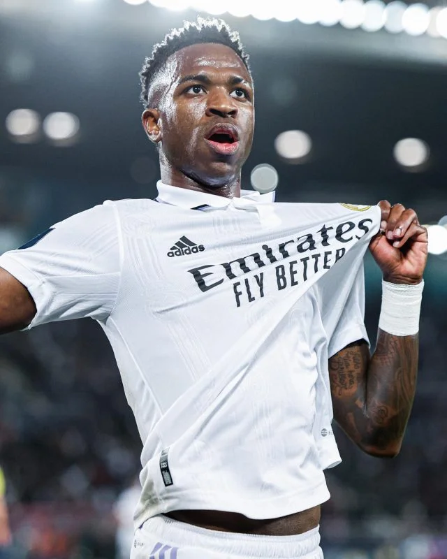 Vinicius Júnior exibe o escudo do Real Madrid após marcar um gol pelo time da Espanha